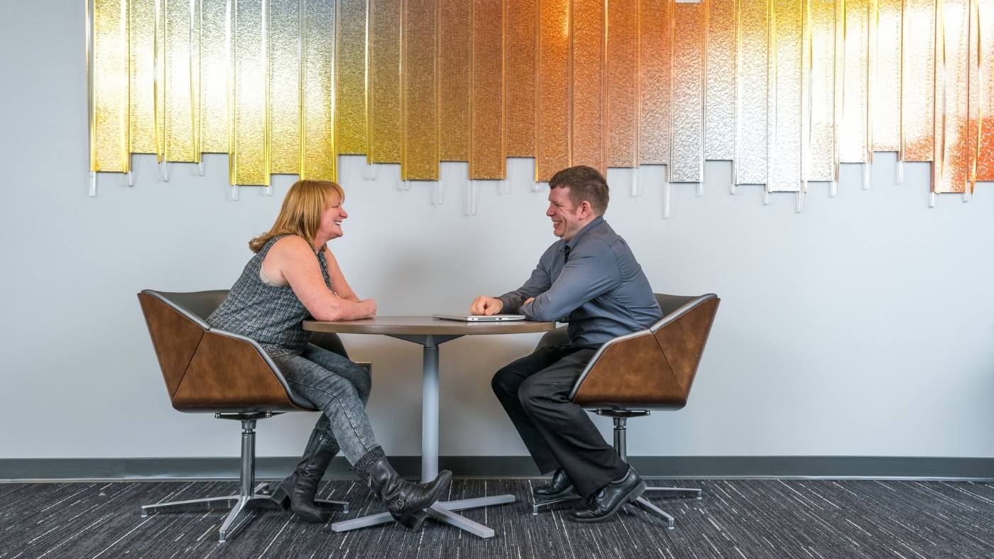 Two GM employees sitting and talking