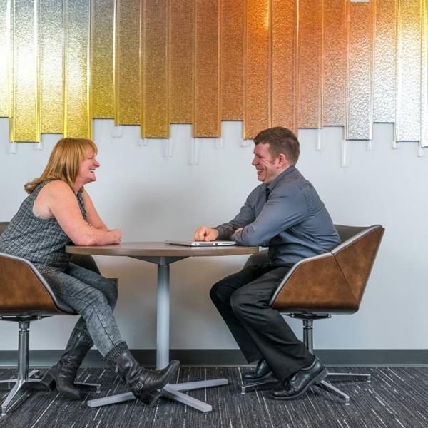 Two GM employees sitting and talking