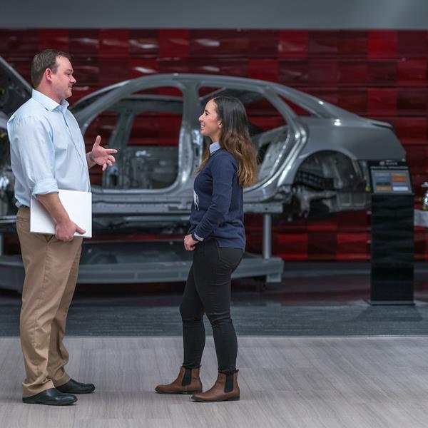 Two GM employees talking.