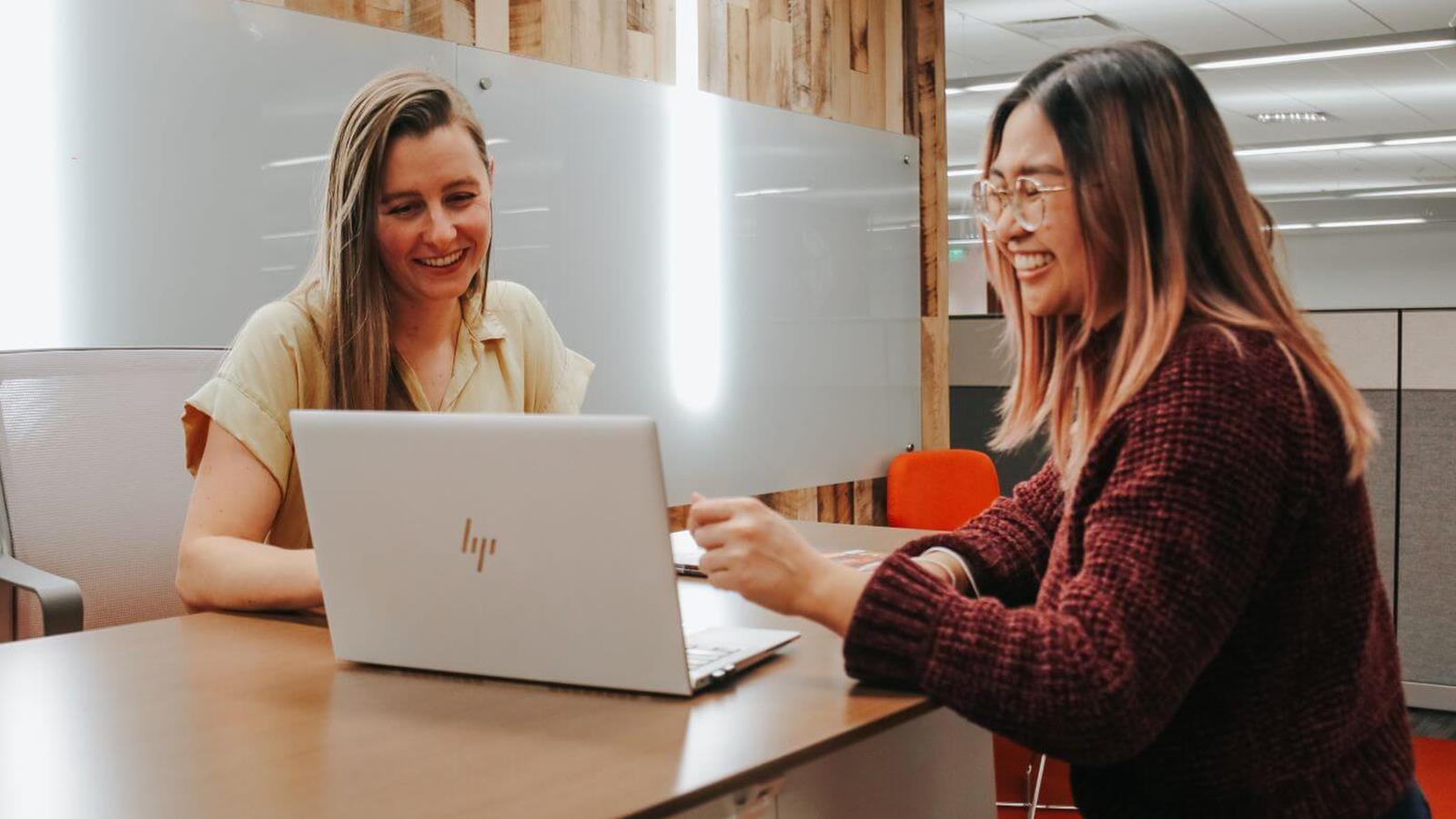 Two GM employees working together on a laptop.