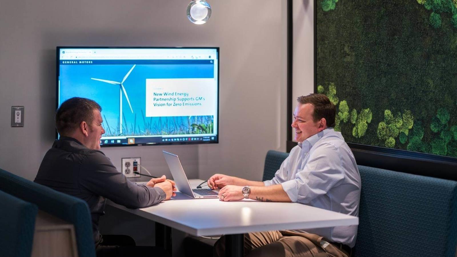 Two employees meeting in an office discussing sustainability