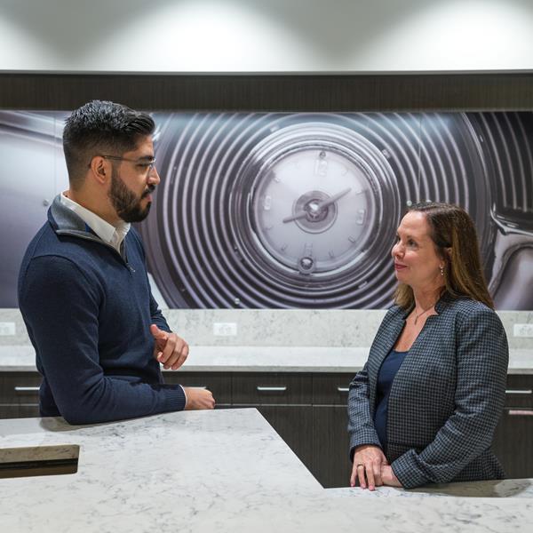 Two GM employees talk in the common area