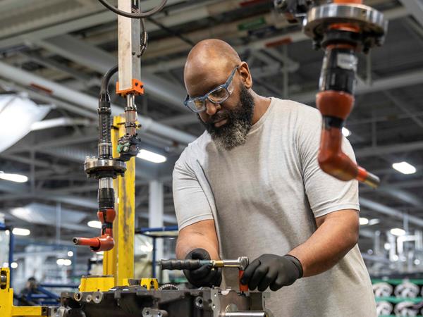 Man in safety glasses working on vehicle part